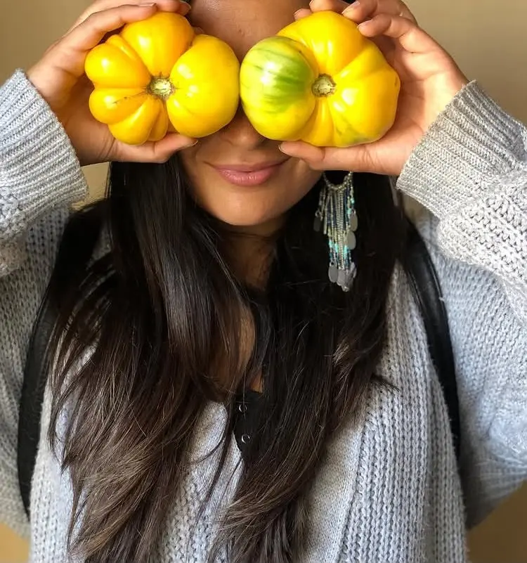 Fundadora de Re Orgánico sosteniendo tomates cultivados de forma natural